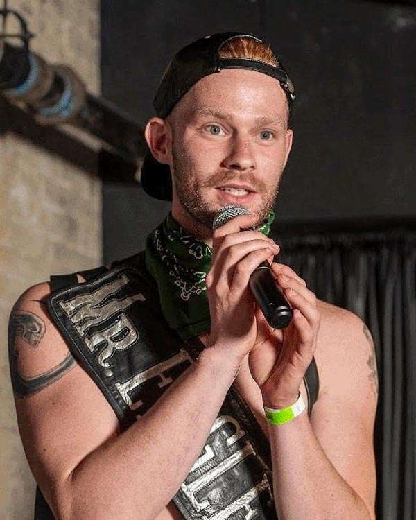 Chris Kelley Winner of Mr. Eagle NYC 2023 Contest holding a mic